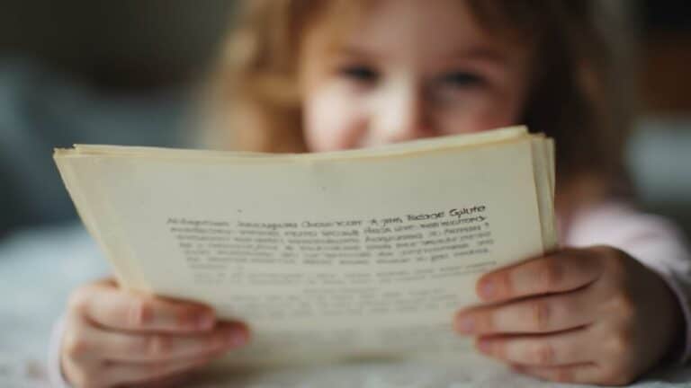 Portrait d'un jeune enfant blond lisant attentivement un livre