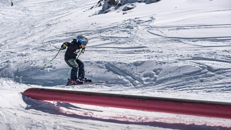 A man riding skis down the side of a snow covered slope