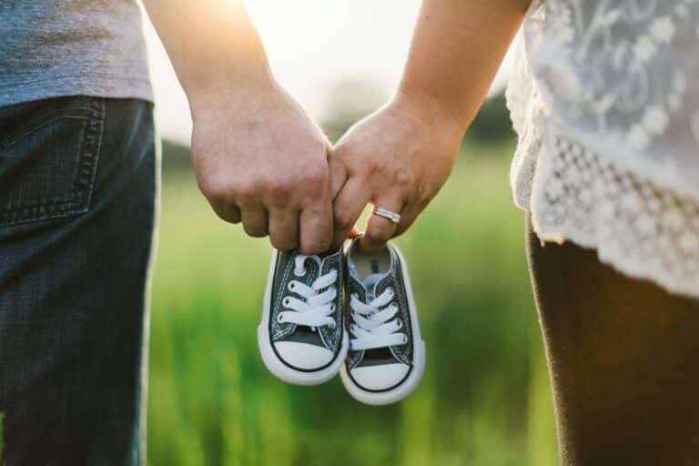 La liste de naissance : le guide complet pour bien la préparer woman and man holding black crib shoes standing near green grass during daytime